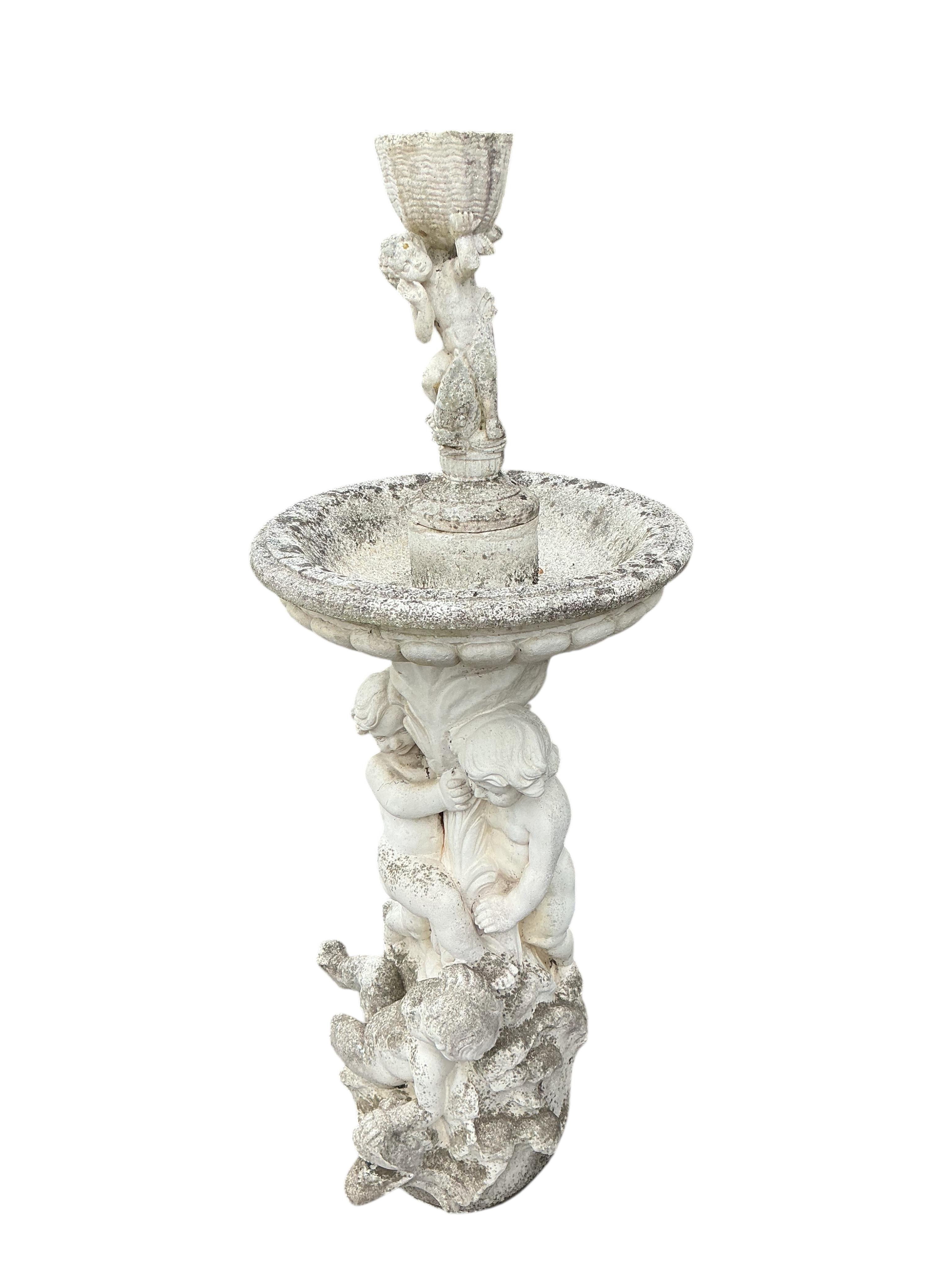 A reconstituted stone cherub and dolphin garden fountain, height 134cm